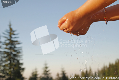 Image of fresh water falling on children hands