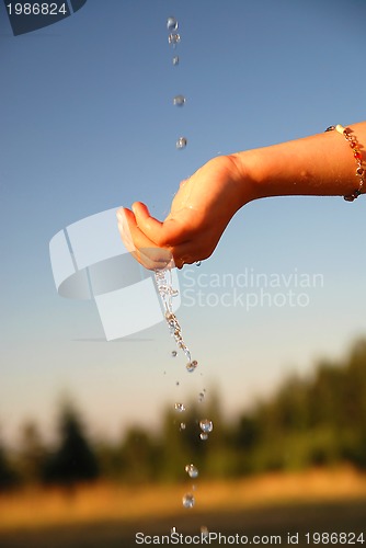 Image of fresh water falling on children hands