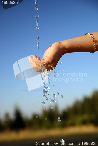Image of fresh water falling on children hands