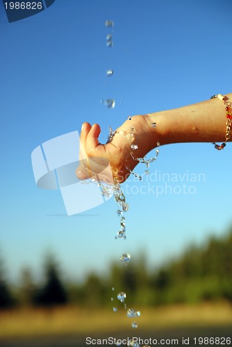 Image of fresh water falling on children hands