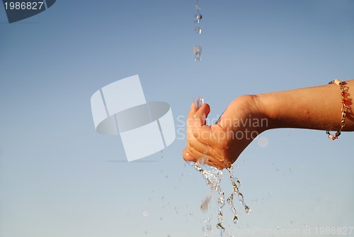 Image of fresh water falling on children hands