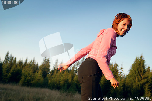 Image of pretty girl doing exercise in nature