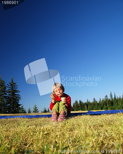 Image of cute little girl eating healthy food outdoor