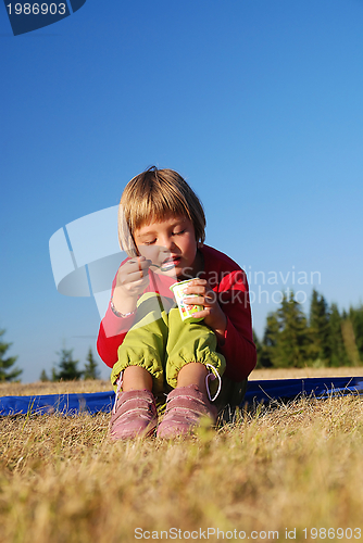 Image of cute little girl eating healthy food outdoor