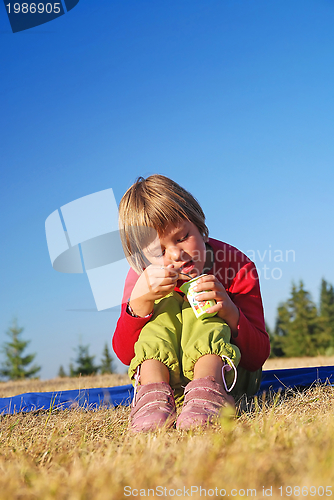 Image of cute little girl eating healthy food outdoor