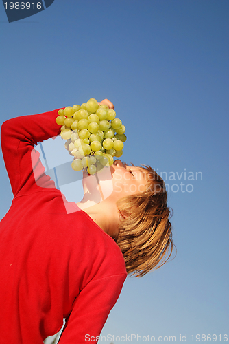 Image of happy girl with grape outside