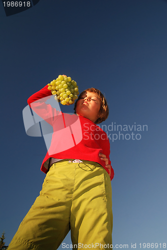 Image of happy girl with grape outside