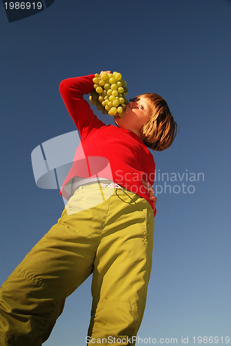Image of happy girl with grape outside