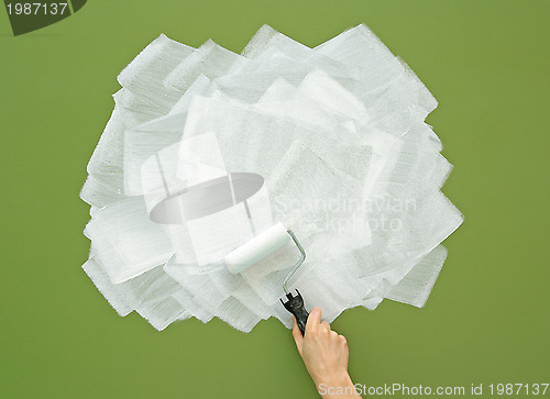 Image of Painting green wall in white color with paint roller