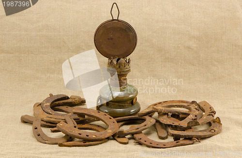 Image of retro kerosene lamp rusty horse shoes linen 