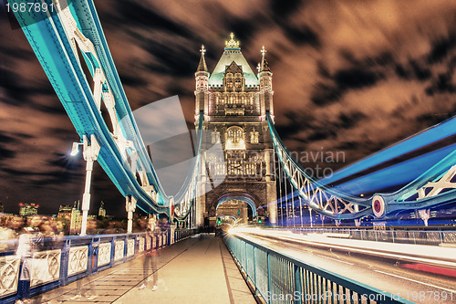 Image of Detail of Tower Bridge in London at night with car light trail -
