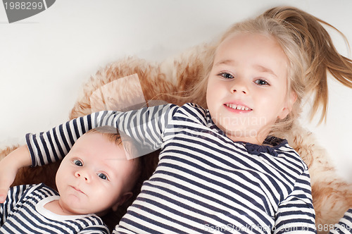 Image of Newborn baby with sister in striped clothes