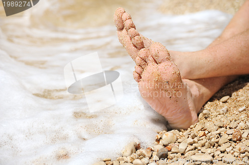 Image of Relaxation on beach, detail of male feet