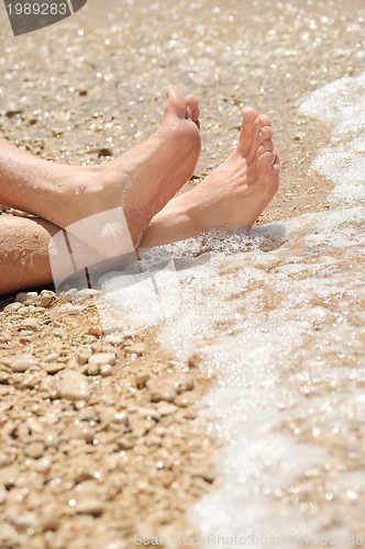 Image of Relaxation on beach, detail of male feet