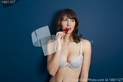 Image of Beautiful woman eating a strawberrie