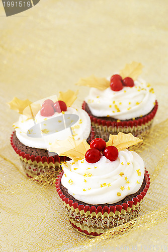 Image of Christmas cupcakes with gold leaves and red berries