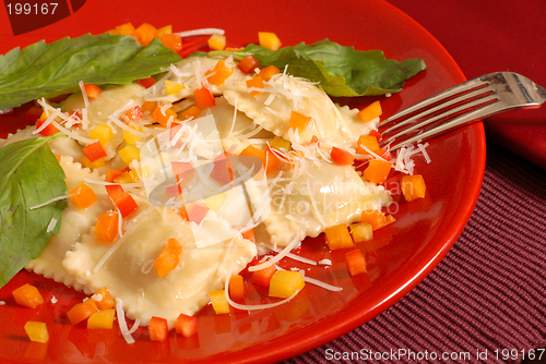 Image of Ravioli topped with diced red, yellow and orange peppers with ba