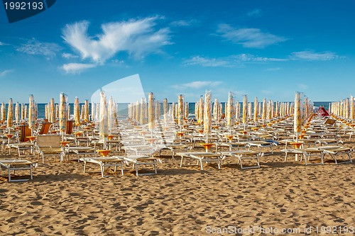 Image of withdrawn umbrellas and sunlongers on the sandy beach