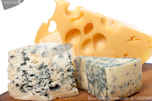 Image of Different types of cheese on old wooden kitchen board