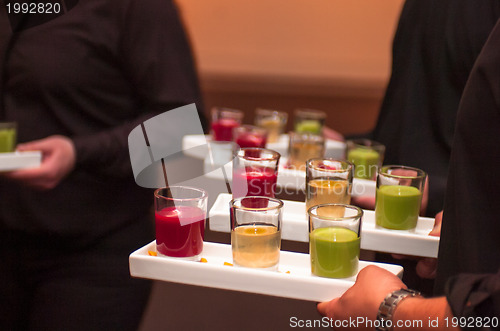 Image of Servers holding colored shot glasses