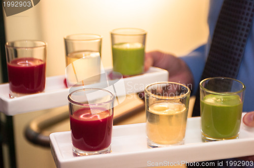 Image of Servers holding colored shot glasses