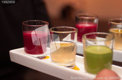 Image of Servers holding colored shot glasses