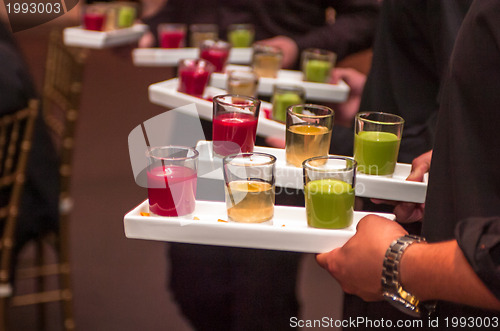 Image of Servers holding colored shot glasses