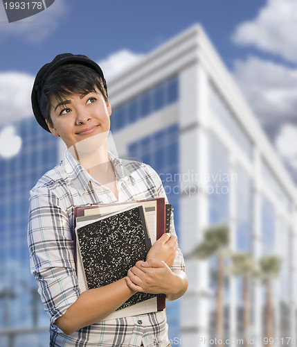 Image of Mixed Race Female Student Holding Books in Front of Building