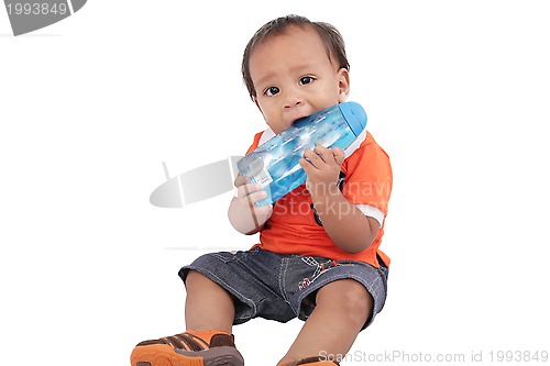 Image of Adorable one year old child biting bottle and smiling, isolated 