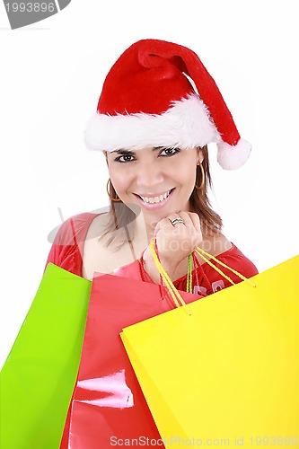Image of Happy woman in Santa hat holding shopping bags, over a white bac