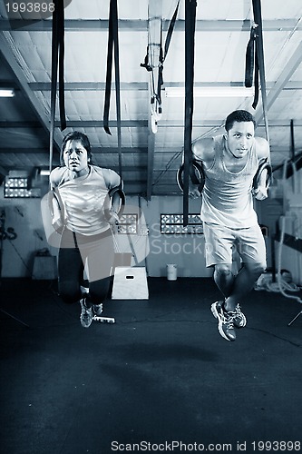 Image of Young gymnasts training on rings on a dark background