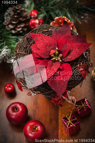 Image of Christmas flower with decoration on wooden table