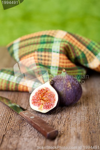 Image of  fresh figs, old knife and chequered towel 