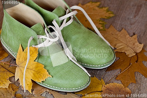 Image of green leather boots and yellow leaves 