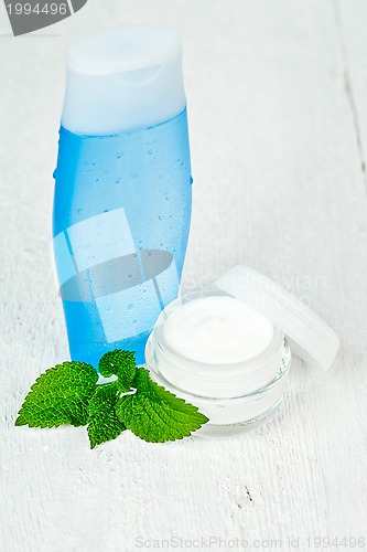 Image of face cream and lotion with urtica leaves 