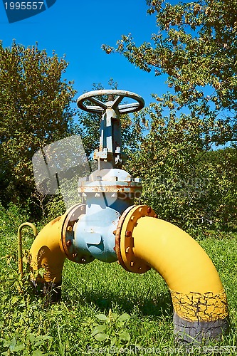 Image of Gas pipe with a valve on a green lawn