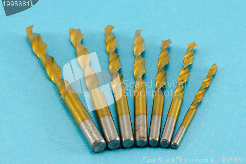 Image of golden drill bits on blue 