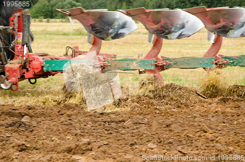 Image of Closeup tractor plough plowing agricultural field 