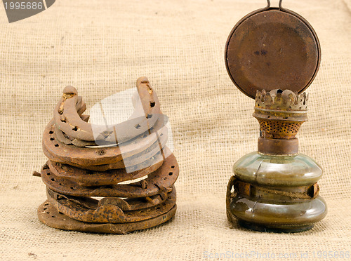 Image of retro kerosene lamp rusty horse shoes linen 