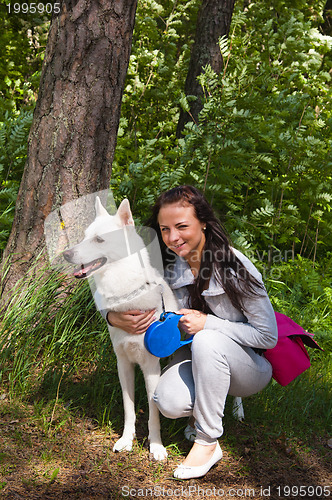 Image of The young woman with a white dog on the nature