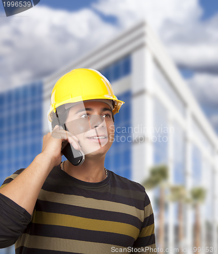 Image of Hispanic Male Contractor on Phone in Front of Building