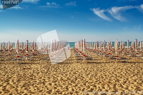 Image of withdrawn umbrellas and sunlongers on the sandy beach