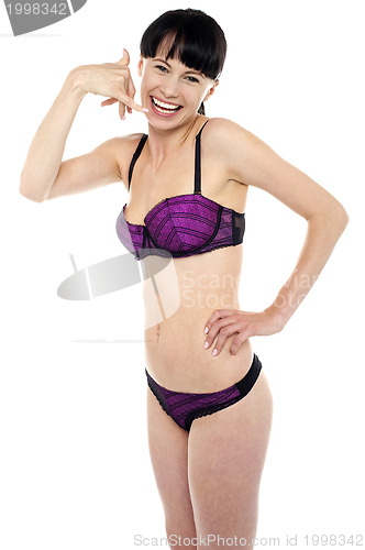 Image of Attractive brunette in bikini gesturing a mock call