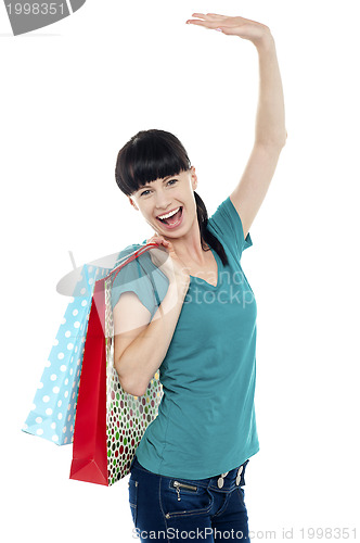 Image of Excited shopaholic woman carrying bags