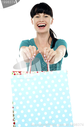 Image of Cheerful woman holding polka dot shopping bags