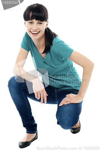 Image of Good looking female model in squatting posture
