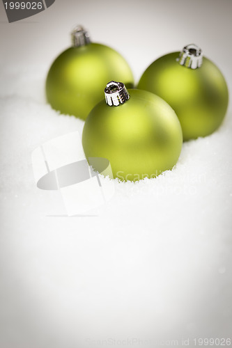 Image of Green Christmas Ornaments on Snow Flakes with Text Room