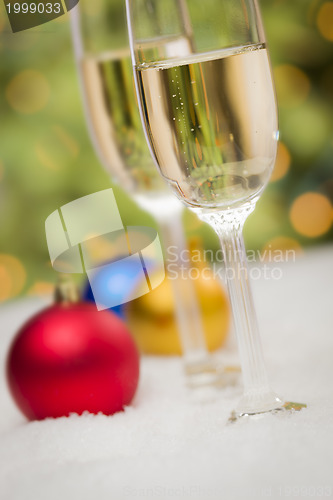 Image of Christmas Ornaments and Champagne Glasses on Snow