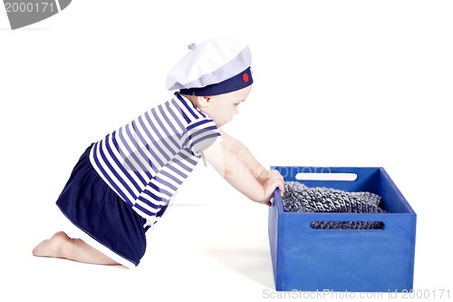 Image of cute little baby in sailor fashion playing 