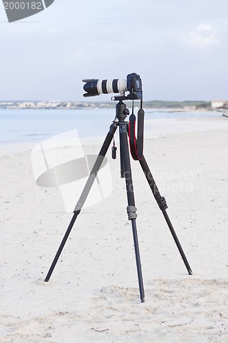 Image of digital slr camera on tripod on beach in summer